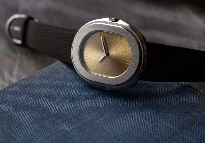 Serica Watches - Gros plan sur montre SERICA 1174-1 Parade automatique. Cadran or, boîtier en acier posé sur tissu bleu.