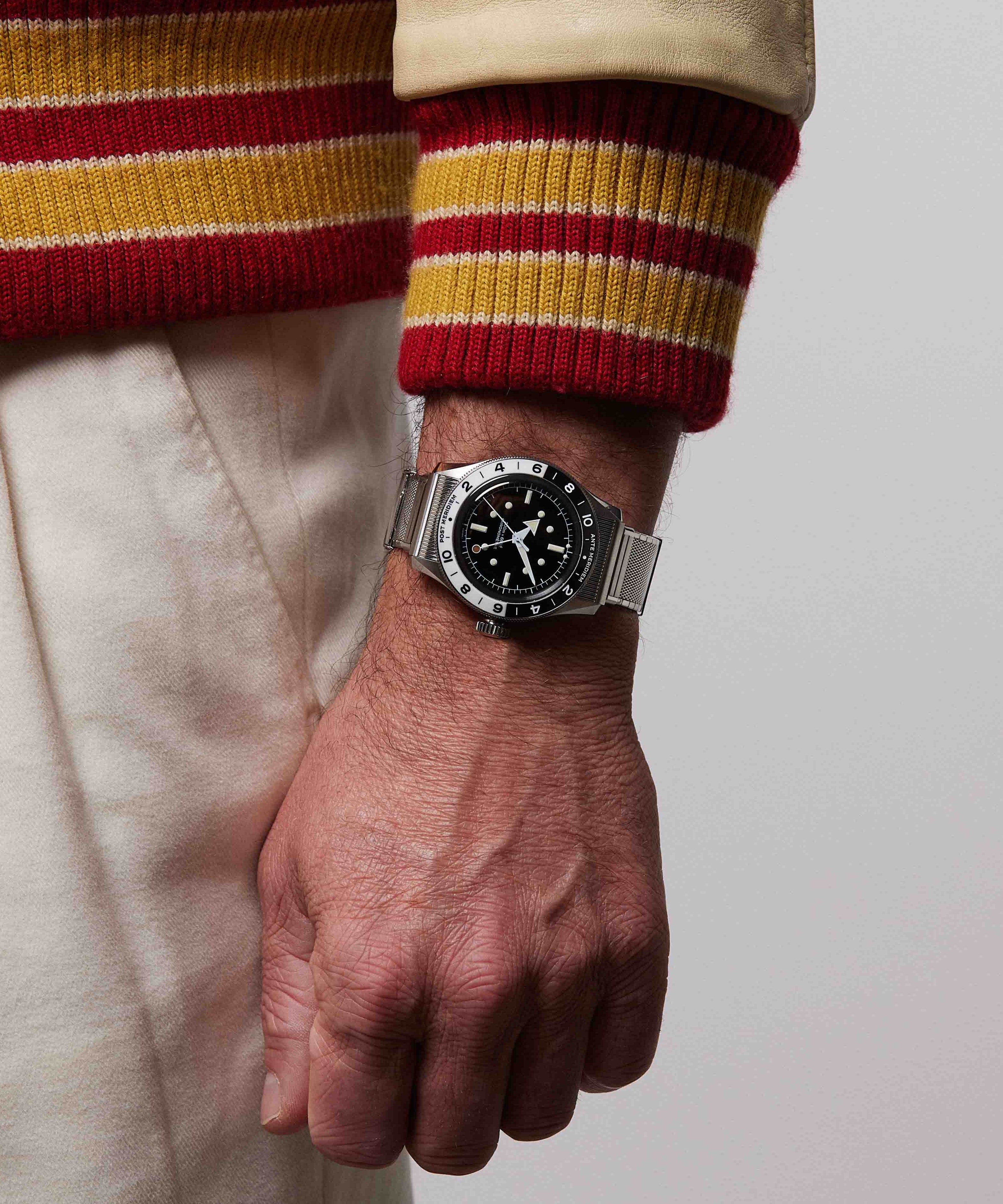 Serica Watches - Gros plan sur le poignet d'un homme portant la montre SERICA 8315-1 GMT noir avec bracelet en acier.