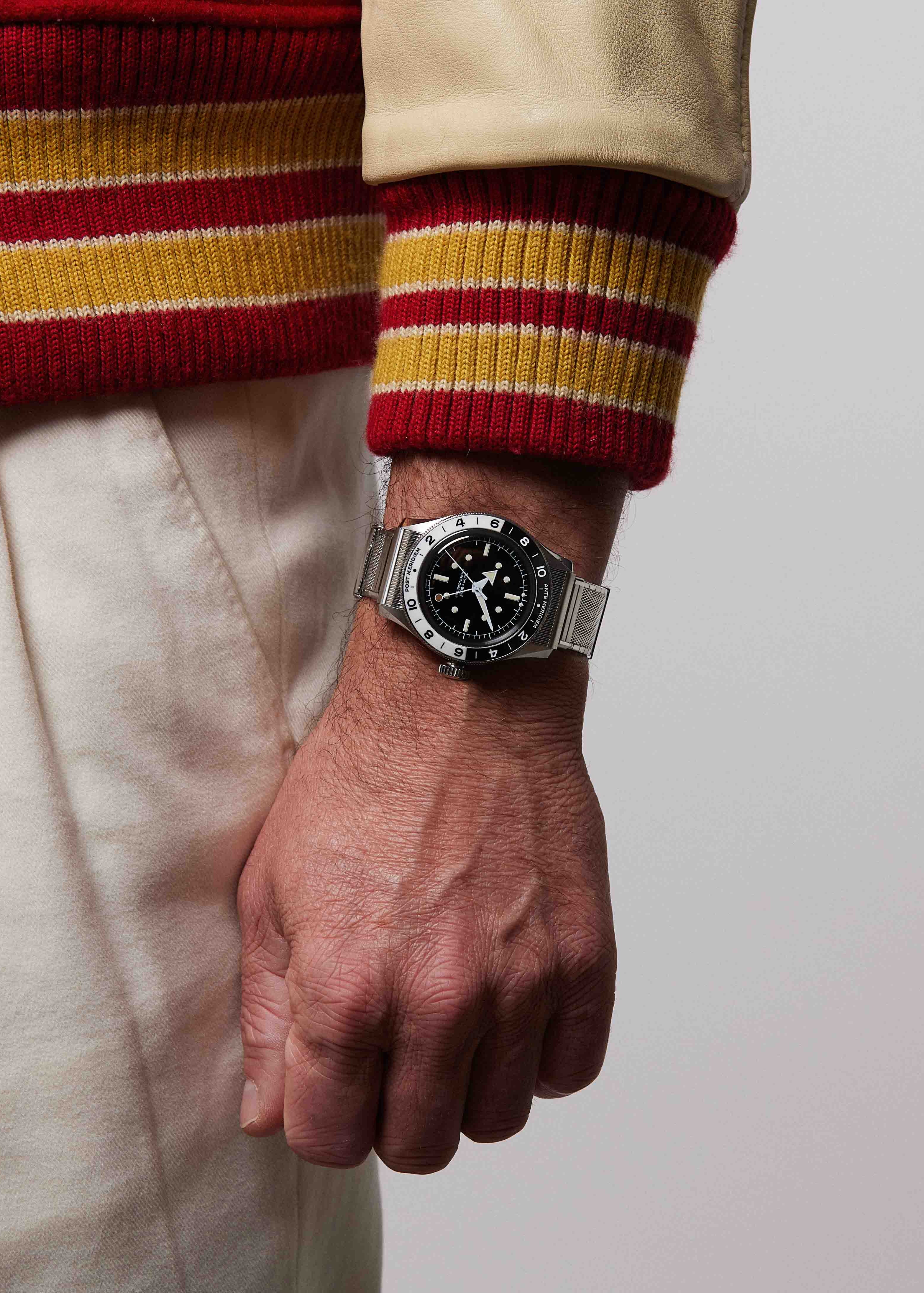 Serica Watches - Gros plan sur le poignet d'un homme portant la montre SERICA 8315-1 GMT noir avec bracelet en acier.