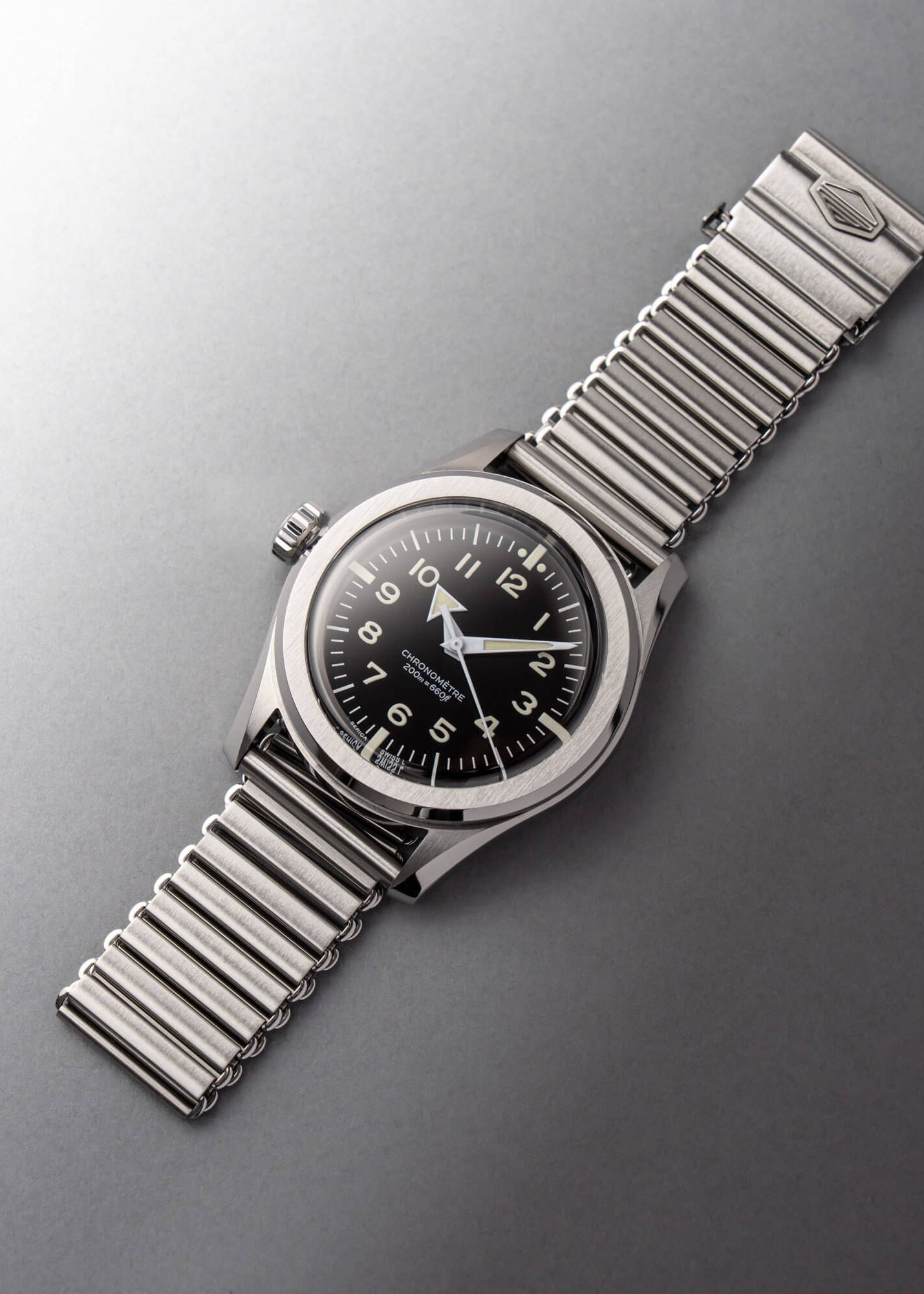 Serica Watches - Nature morte horlogère épurée mettant en scène le chronomètre SERICA 6190 Commando monté sur son bracelet en acier Bonklip.